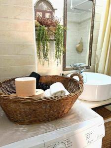 a bathroom with a basket of towels and a sink at Ammoudara Apartment's in Kalymnos