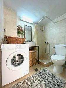 a bathroom with a washing machine and a toilet at Ammoudara Apartment's in Kalymnos