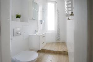 een witte badkamer met een toilet en een wastafel bij Restful Stay Apartment in Grudziądz