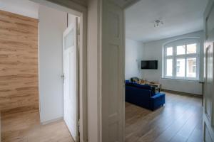 een woonkamer met een blauwe bank en een raam bij Restful Stay Apartment in Grudziądz