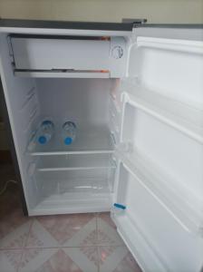 um frigorífico aberto com duas garrafas de água em JATUPORN A3 em Ban Talat Rangsit