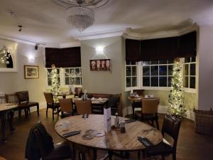 ein Restaurant mit Tischen, Stühlen und Weihnachtsbäumen in der Unterkunft The Manifold Inn Hotel in Hartington