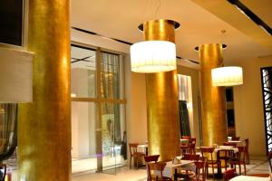 a restaurant with tables and chairs and gold columns at Evridiki in Kilkís