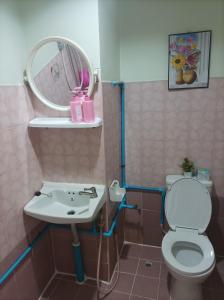 uma casa de banho com um lavatório, um WC e um espelho. em JATUPORN A3 em Ban Talat Rangsit