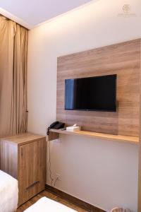 a hotel room with a flat screen tv on a wall at Worth Elite Hotel in Makkah