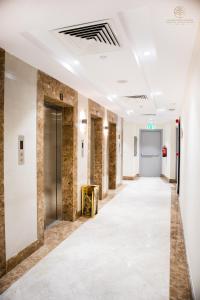 um corredor de um edifício com paredes brancas e um longo corredor em Worth Elite Hotel em Meca