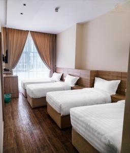 um quarto de hotel com três camas e uma janela em Worth Elite Hotel em Meca
