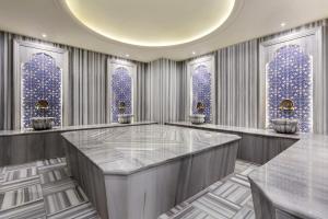 a lobby with blue windows and a large marble table at Ramada by Wyndham Istanbul Umraniye in Istanbul