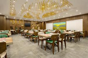 a dining room with tables and chairs and chandeliers at Ramada by Wyndham Istanbul Umraniye in Istanbul