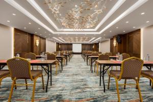 a row of tables and chairs in a room with a ceiling at Ramada by Wyndham Istanbul Umraniye in Istanbul