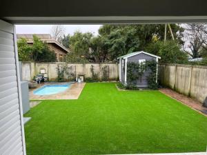 a backyard with a green lawn and a swimming pool at 7de Hemel Paarl in Paarl