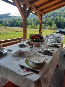 a long table with plates and wine glasses on it at Casa PICY Vendégház in Sovata