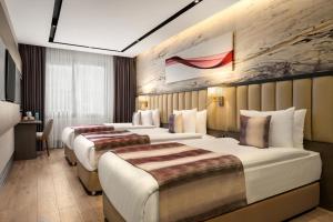 a hotel room with three beds in it at Ramada by Wyndham Istanbul Umraniye in Istanbul