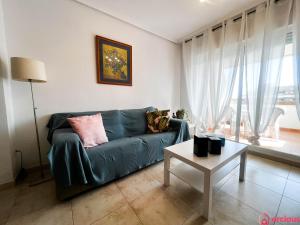 een woonkamer met een groene bank en een tafel bij Como pez en el agua in Oropesa del Mar