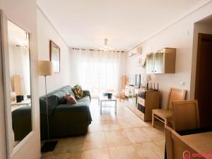 een woonkamer met een bank en een keuken bij Como pez en el agua in Oropesa del Mar