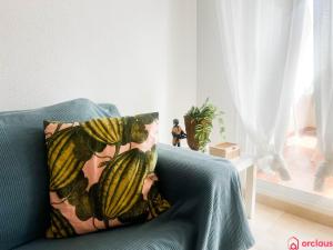 een blauwe bank met een kussen met een plant erop bij Como pez en el agua in Oropesa del Mar