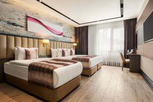 a hotel room with two beds and a tv at Ramada by Wyndham Istanbul Umraniye in Istanbul