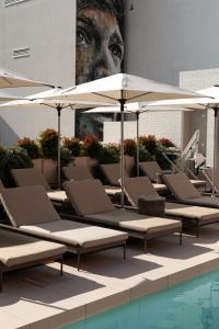 a group of lounge chairs and umbrellas next to a pool at UMusic Hotel Madrid in Madrid