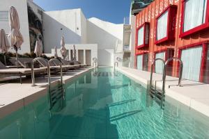 a pool at a hotel with chairs and umbrellas at UMusic Hotel Madrid in Madrid