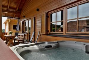 a jacuzzi tub in a room with windows at Chalet Leithenwald in Zwiesel