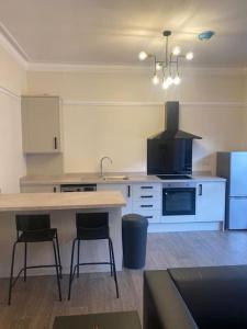 a kitchen with a table and two bar stools at Beautiful ground floor flat in London