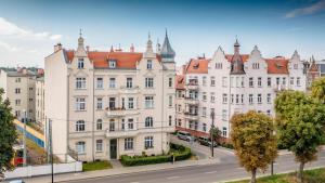 a large white building with a red roof at Cosy Balcony Apartment in Grudziądz