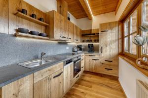 a kitchen with wooden cabinets and a sink at Chalet Leithenwald in Zwiesel