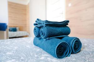 a stack of blue towels sitting on top of a bed at Cosy Balcony Apartment in Grudziądz +48 photos