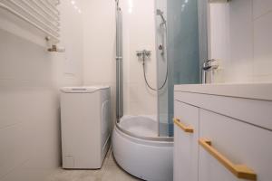 a bathroom with a shower and a toilet and a sink at Cosy Balcony Apartment in Grudziądz