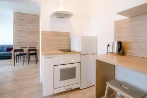 a kitchen with white appliances and a table with chairs at Cosy Balcony Apartment in Grudziądz