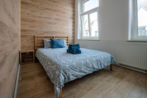een slaapkamer met een bed met een blauwe teddybeer erop bij Cosy Balcony Apartment in Grudziądz