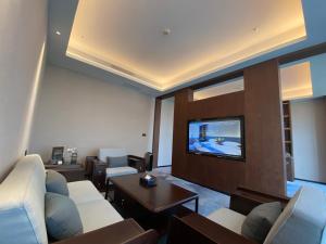 uma sala de estar com sofás e uma televisão de ecrã plano em 云瑞凤凰酒店 em Jinzhong