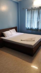 een groot bed in een kamer met een raam bij HOTEL MTM in Digha