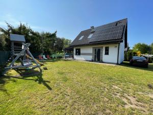 a house with a solar roof on top of a yard at Mazury Dom Oskar nad jeziorem Sasek Wielki in Szczytno