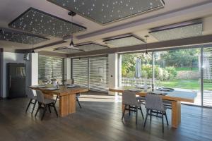 a dining room with a table and chairs and windows at Domaine Rampale in Fuveau