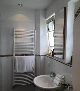 a white bathroom with a sink and a mirror at Unter der Linde 1 in Bad Salzuflen