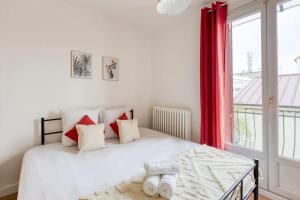 Schlafzimmer mit einem weißen Bett mit roten Vorhängen und einem Fenster in der Unterkunft Cosy house in La Courneuve