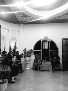 a group of people sitting in a room at Sapo Rumbia Guest House in Berastagi
