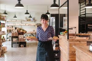 una mujer sosteniendo dos platos de comida en una tienda en Landwarenhaus Gross Beuchow, en Groß Beuchow