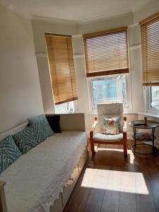 a living room with a couch and a chair and windows at Ocean City Apartment-with parking in Plymouth