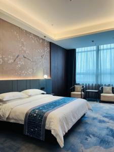 um quarto com uma cama grande e uma pintura grande na parede em 云瑞凤凰酒店 em Jinzhong