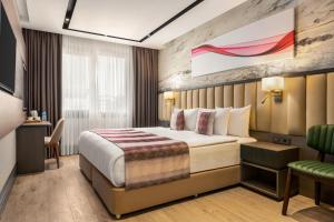 a hotel room with a bed and a chair at Ramada by Wyndham Istanbul Umraniye in Istanbul