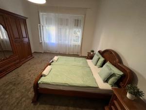 um quarto com uma cama com lençóis verdes e uma janela em VILLA HANNA em Tokaj