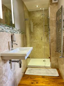 uma casa de banho com um lavatório e um chuveiro em The Mainstay Luxury Boutique Rooms with Private Parking em Whitby
