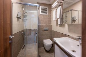 y baño con ducha, aseo y lavamanos. en Comfort Suites Hotel en Estambul