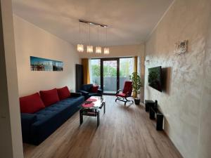 een woonkamer met een blauwe bank en een tafel bij Vip Locum Hanza Szczecin in Szczecin