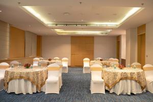 una sala de conferencias con mesas, sillas y mesa en Sheraton Hyderabad Hotel en Hyderabad