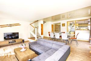 a living room with a couch and a table at Bargkass - Vue montagne et piscine in La Bresse