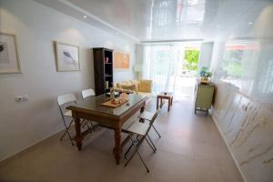 a living room with a wooden table and chairs at Chaparal Design Apartment in Costa Del Silencio +11 photos