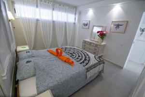een slaapkamer met een bed met een oranje speeltje erop bij Chaparal Design Apartment in Costa Del Silencio